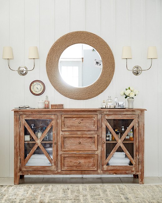 In case the rope frame of the Quincy mirror isn’t nautical enough, its shape references a porthole. Adding to the beachy theme is the driftwood-esque finish of the Brielle sideboard. Find similar sconces here.
